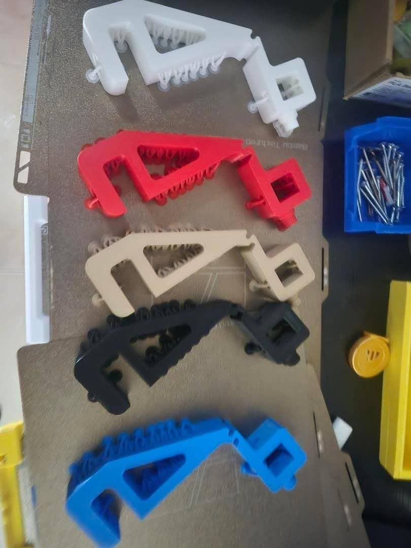 Five colored MechAMS bracket parts printed on a build plate