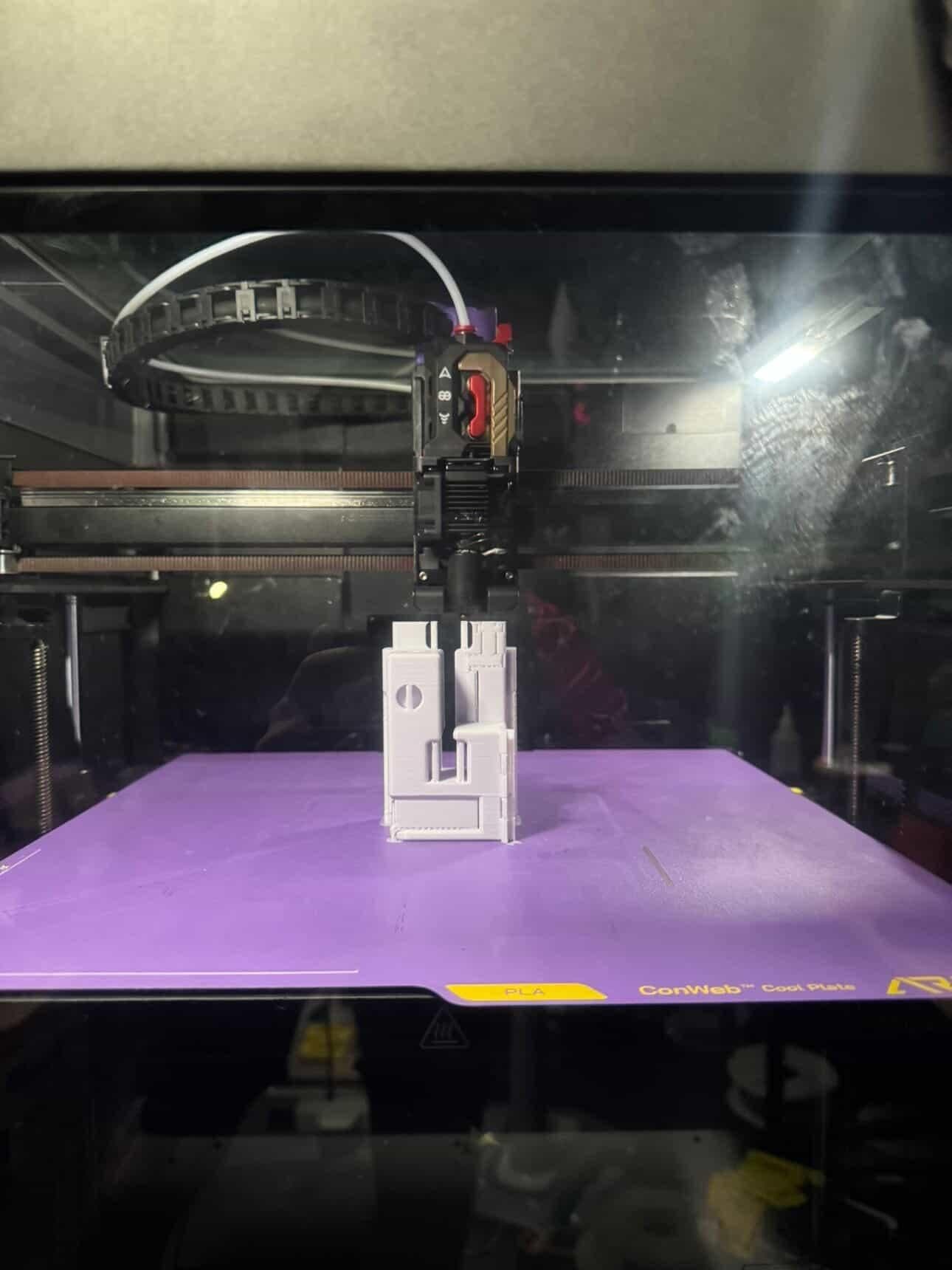 Toolhead housing print in progress on a purple build plate